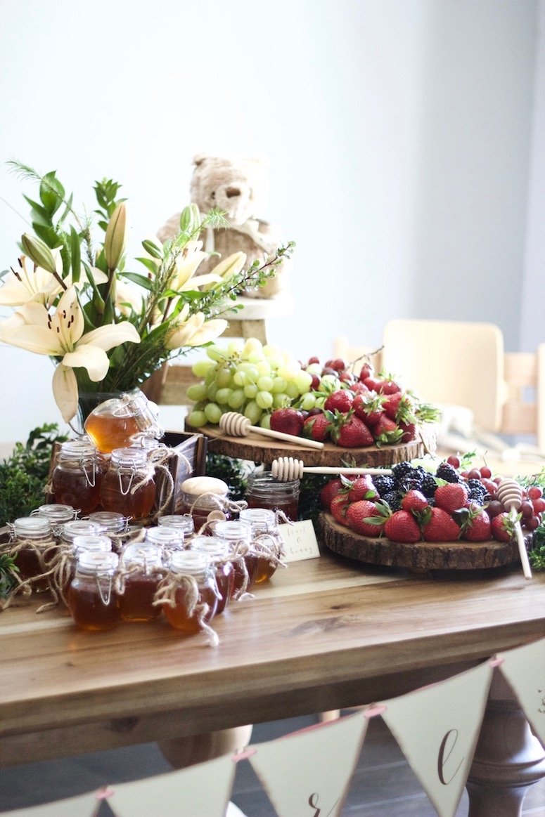 Classic Winnie the Pooh baby shower, a tablescape full of fruit and honey for the guests! Click to see more photos from this beautiful baby shower