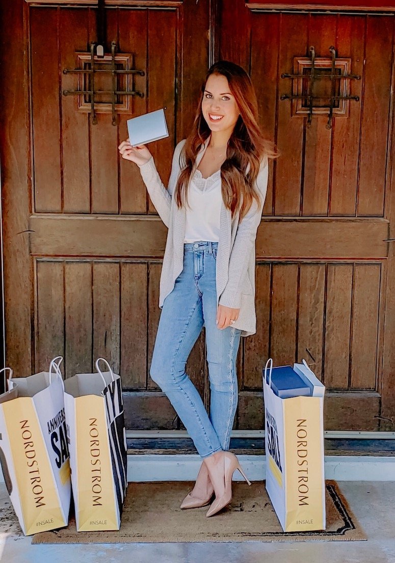 brunette woman with nordstrom anniversary sale shopping tips and bags