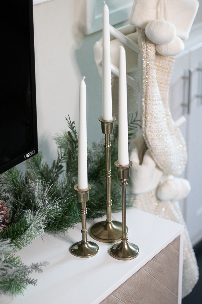 gold candlesticks on tv stand decorated for christmas