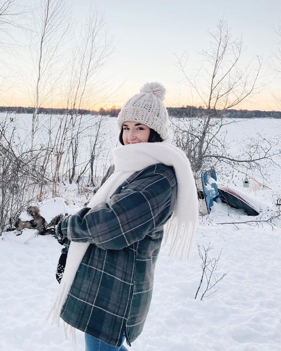 woman playing in the snow with a large white scarf