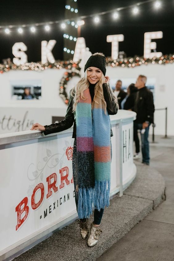 woman next to ice skating rink wearing a bold scarf, outfits to wear ice skating