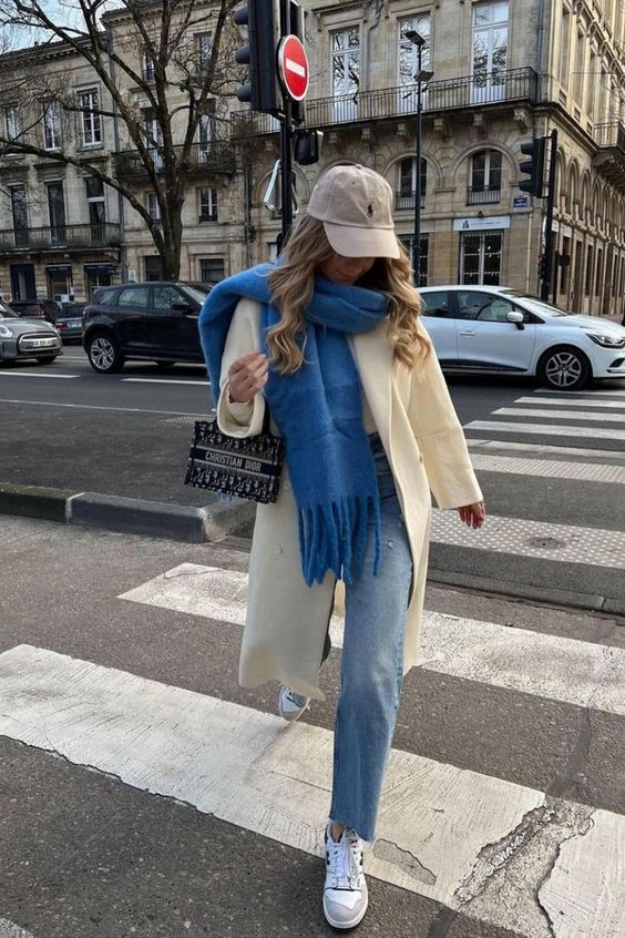 woman walking across the street with a blue scarf, outfits to wear ice skating