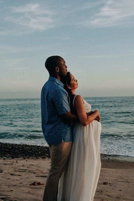 couples maternity photoshoot on the beach