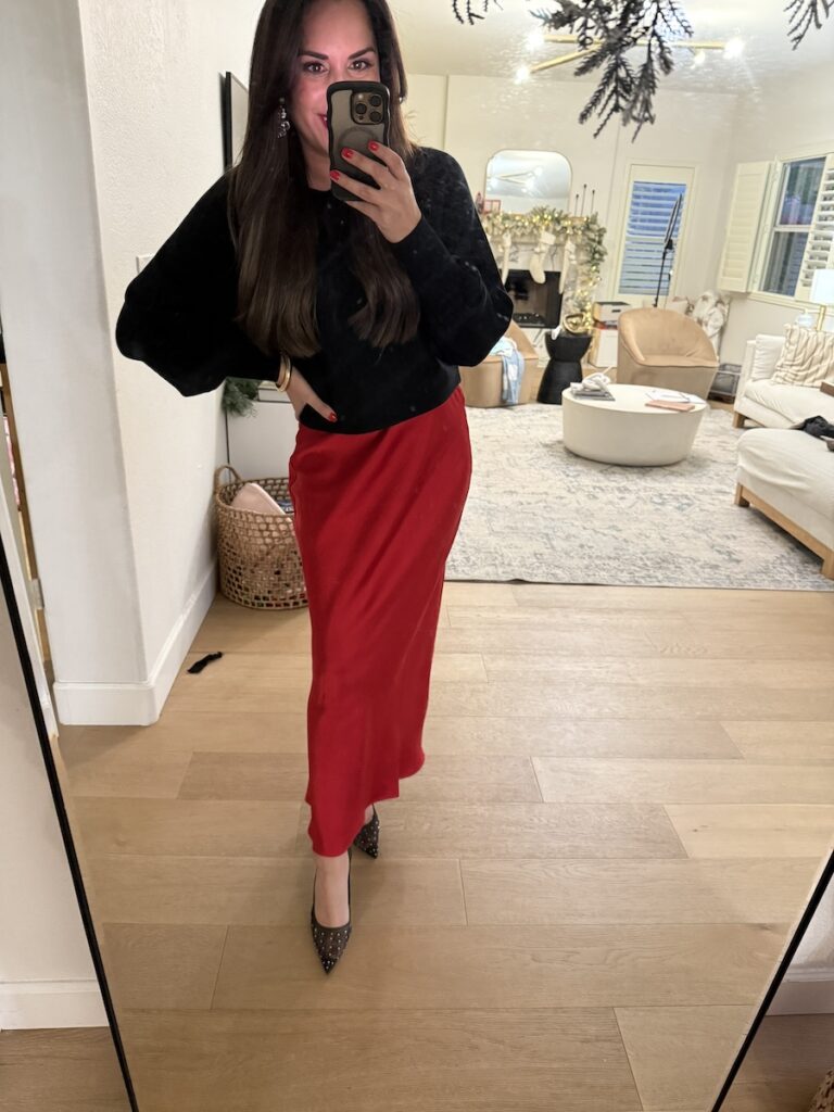 satin red skirt with black sweater holiday outfit