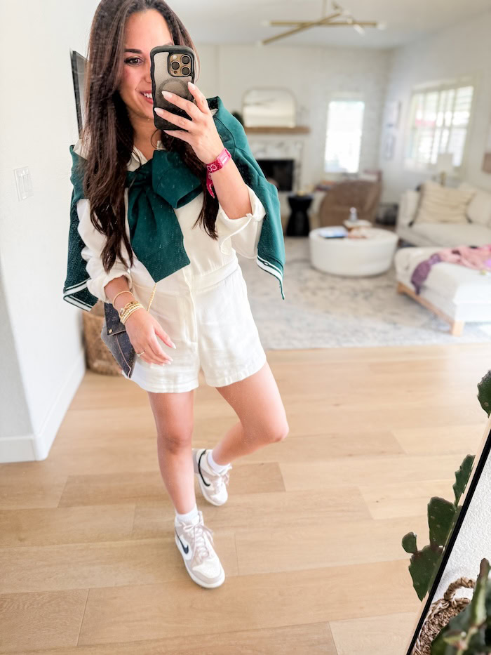 L'Academie Dylan white romper styled with a teal tweed cardigan, sneakers, and denim bag, mirror selfie vacation outfit